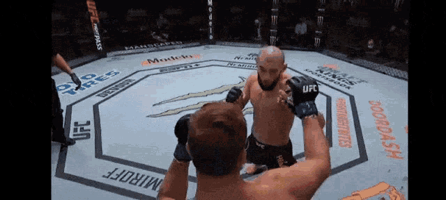 two men in a boxing ring with ufc written on the ground