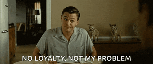 a man is sitting at a table with a plate of food and says " no loyalty , not my problem "