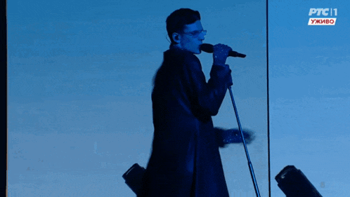 a man singing into a microphone with ptc 11 written on the bottom right