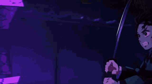 a man is holding a sword in a dark room surrounded by flames .