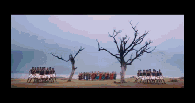 a group of people are standing in a field with trees in the background
