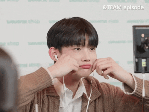 a young man wearing earbuds is making a funny face with the words & team episode behind him