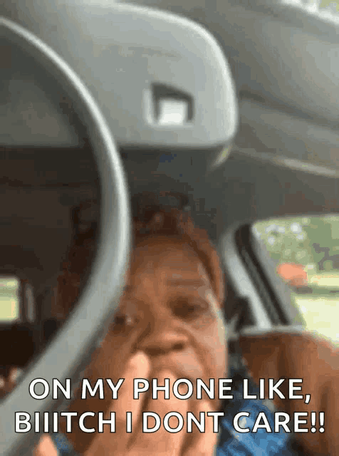 a woman in a car says " on my phone like bitch i dont care !! "