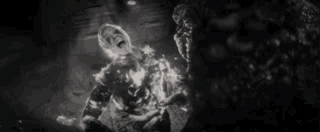 a black and white photo of a man being burned by a monster .