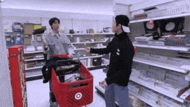 a man pushing a shopping cart in a store with a sign that says ' target ' on it