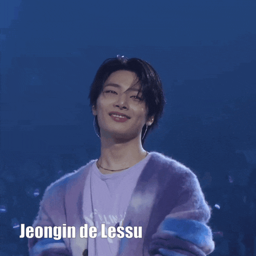 a young man wearing a purple cardigan and a purple shirt with the name jeongin de lessu