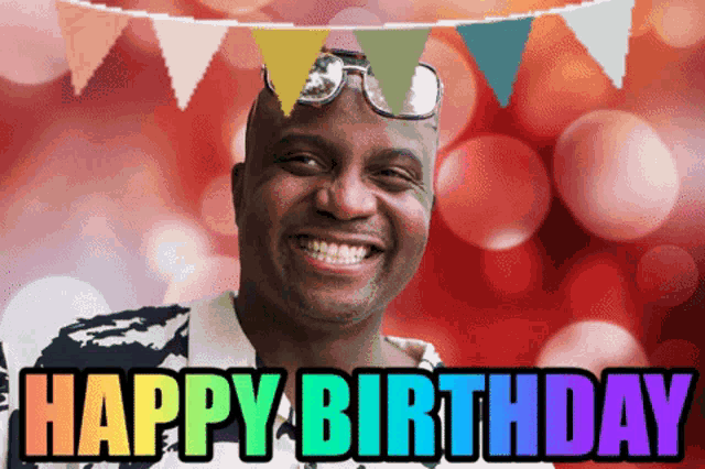 a man is smiling in front of a banner that says " happy birthday "
