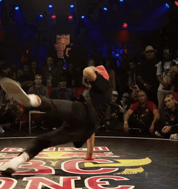 a man is doing a handstand in front of a crowd at a red bull dance competition