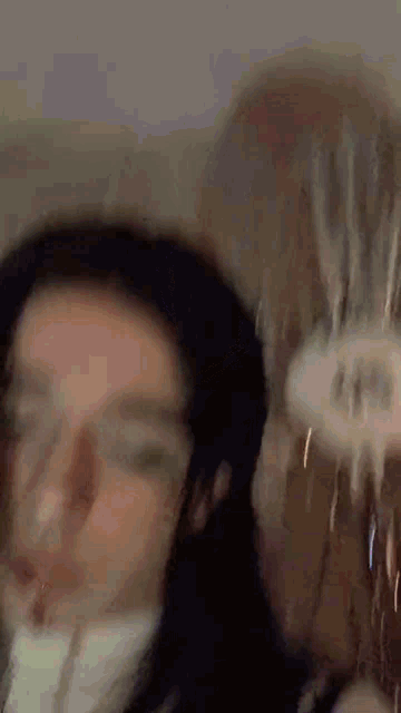 a blurry picture of a woman 's face with water coming out of it .