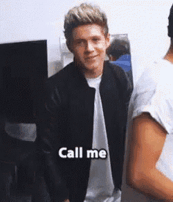 a man in a black jacket is standing next to a man in a white shirt and says call me .