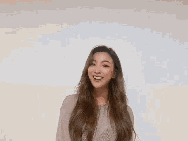 a woman is making a heart shape with her hands while smiling .