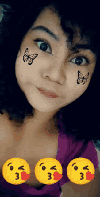 a girl with butterflies painted on her face has three smiley faces on her chest