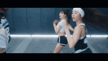 a group of women are dancing in a gym