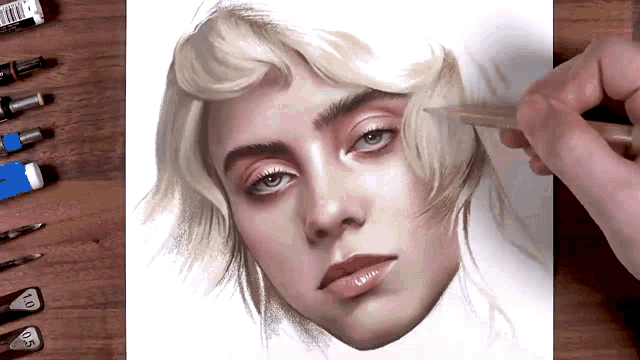 a person is drawing a portrait of billie eilish with a pencil on a piece of paper