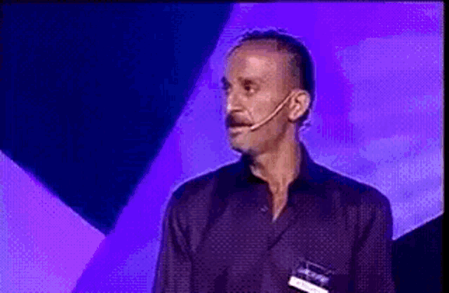a man with a microphone on his head is giving a speech
