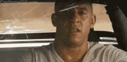 a man is driving a car and looking out the window .