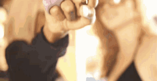 a close up of a person 's hand holding a bottle of perfume .