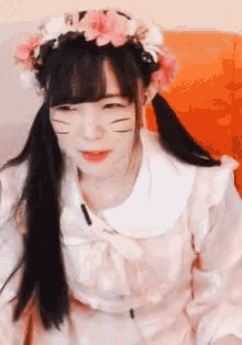 a girl with pigtails and a flower crown on her head is smiling