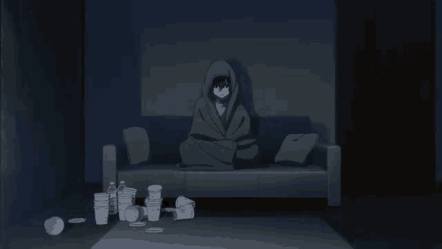 a person is laying on a couch in a dark room with a lot of trash on the floor .