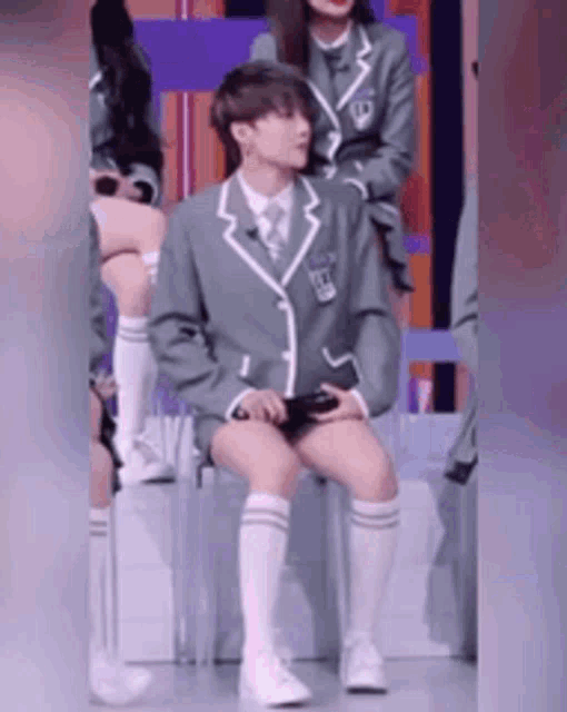 a person in a suit is sitting on a chair with their legs crossed .