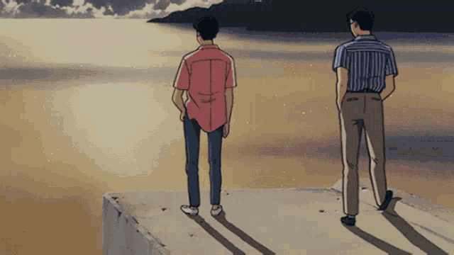 two men are standing on a ledge looking out over the ocean