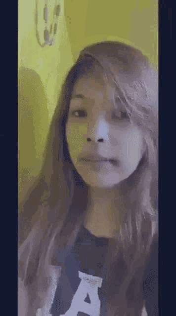a girl with long hair is making a funny face .