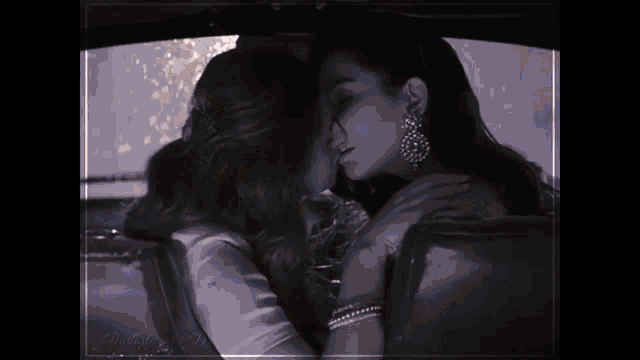 two women are kissing in the back seat of a car ..