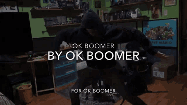 a man in a black hoodie is dancing in a room with the words " ok boomer by ok boomer " above him