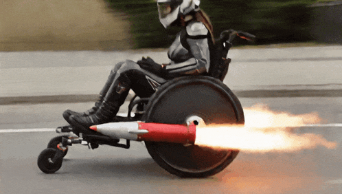 a person in a wheelchair with a rocket attached to the back wheel