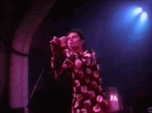 a man is singing into a microphone on stage .