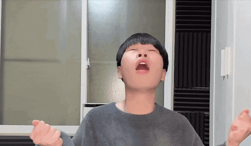 a young boy with his eyes closed is making a funny face