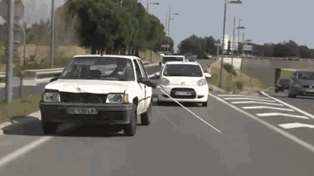 a white car with a license plate that says ic 389 km is driving down a street