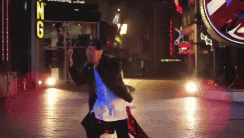 a man is dancing in front of a sign that says ' n g '