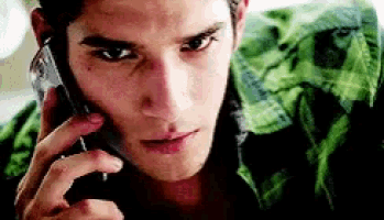 a man is talking on a cell phone with a green shirt on .