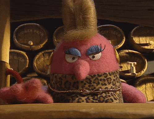 a stuffed animal is sitting in front of a row of ginger beer barrels