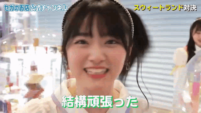 a girl wearing a headband is smiling in a video with chinese writing on it .