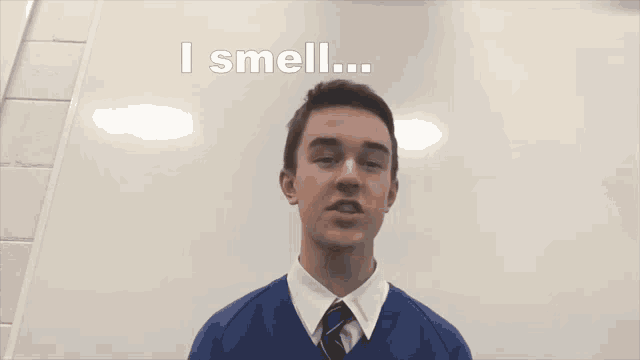 a young man in a blue shirt and tie says i smell