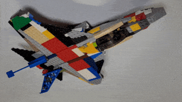 a person is playing with a lego airplane that has a blue tail