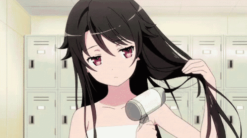 a girl with long black hair is blow drying her hair in a locker room