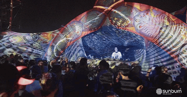 a crowd of people are gathered in front of a stage that says sunburn on the bottom