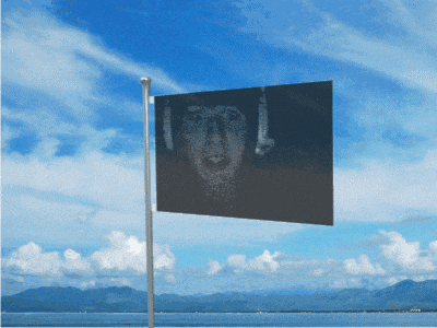 a flag with a picture of a face on it is flying in the wind