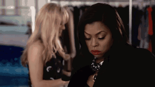 two women are standing next to each other in a closet .