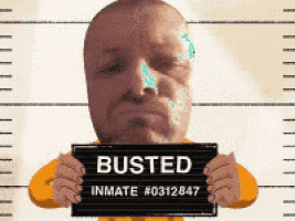 a man is holding up a busted inmate # 0312847 sign