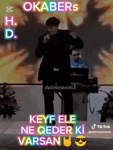 a man singing into a microphone with the words okabers h.d. keyf ele ne qeder ki varsan below him