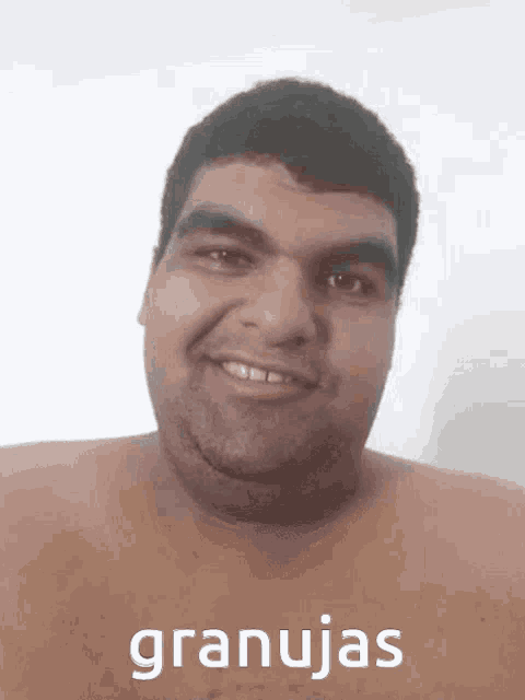 a man without a shirt is smiling with the word granujas written on his chest