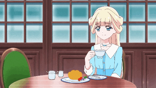 a girl in a blue dress sits at a table drinking tea