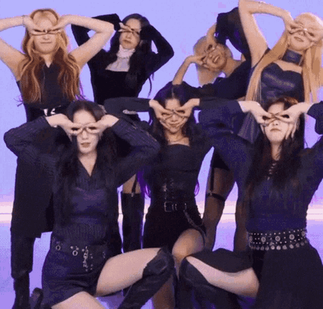 a group of women are posing for a picture with their hands on their faces