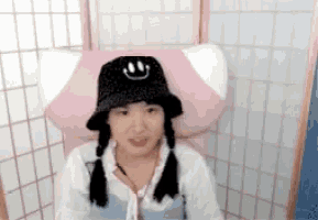 a woman wearing a black hat with a smiley face on it