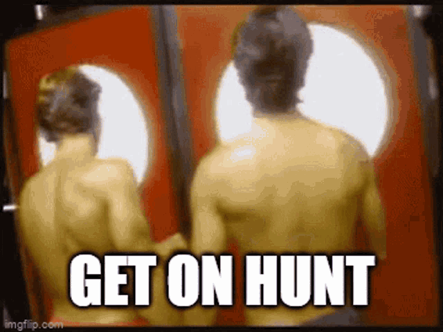 two shirtless men are standing in front of a red door with the words get on hunt written on the bottom .