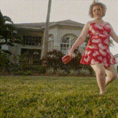 a woman in a red dress is running in a field